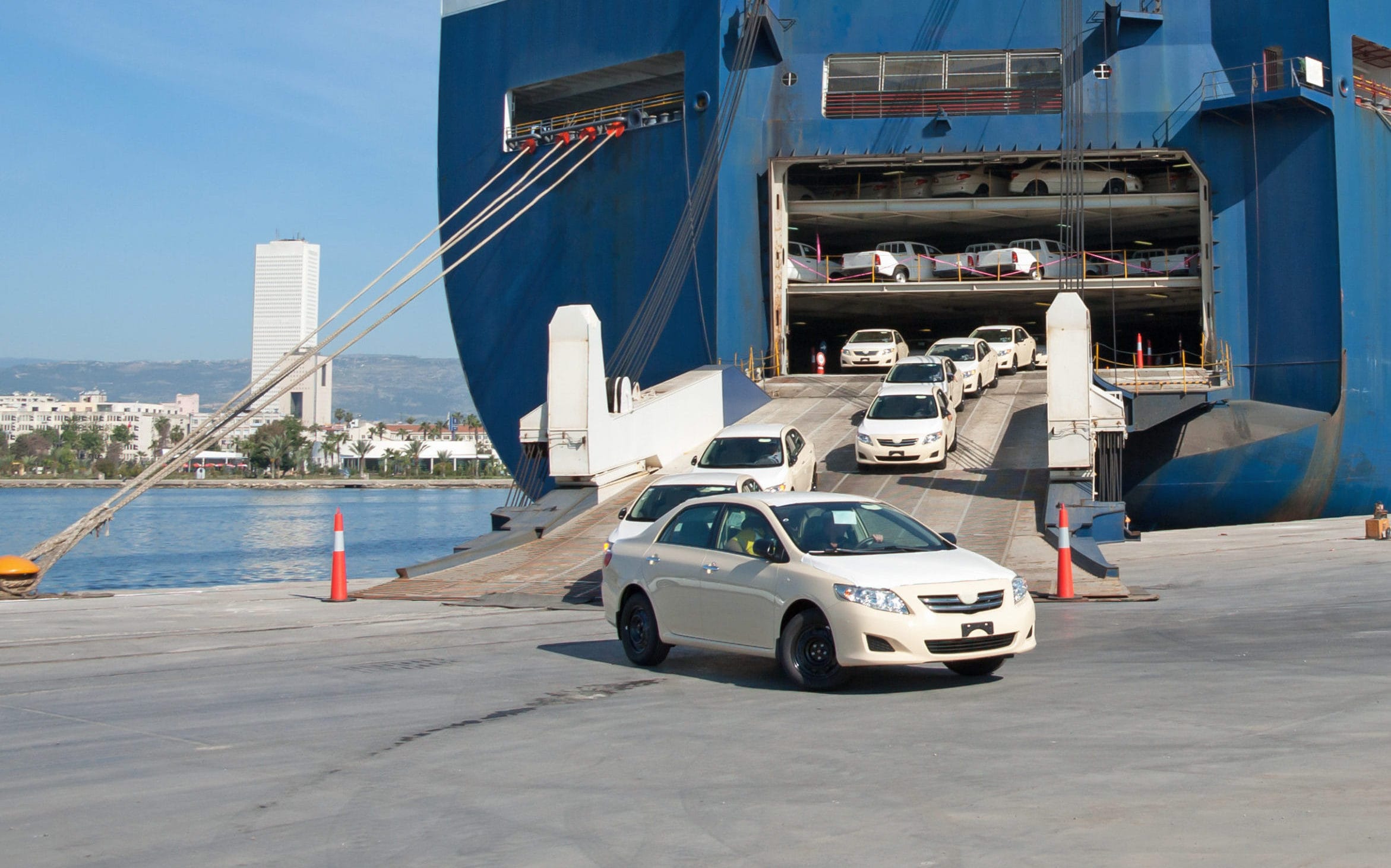 Beige sedan driving off a Roll-on/Roll-off (RoRo) cargo ship, break bulk shipping. -Shipping Company in Egypt